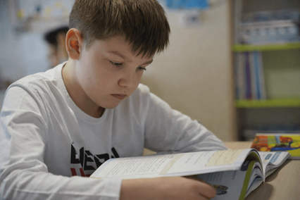 Pupil reading a book at his desk