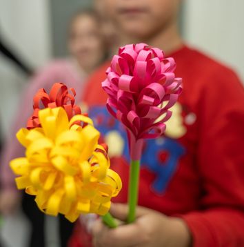Child holding handmade paper flowers
