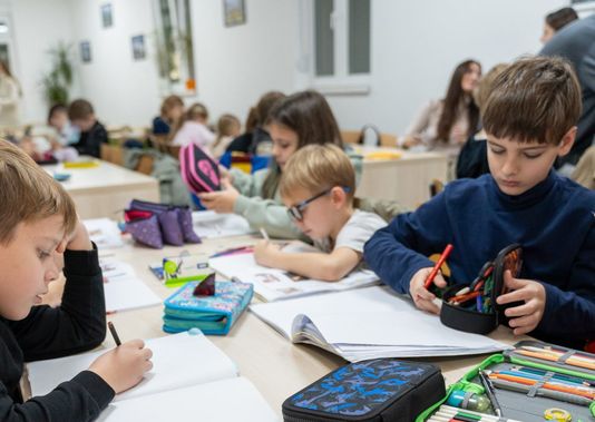 Pupils drawing and writing at their desks in a Clever School classroom