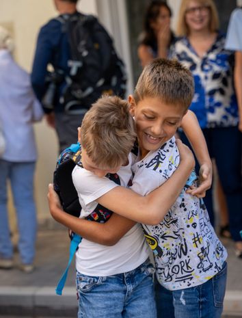 Two pupils hugging at school