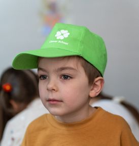 Young pupil wearing a green Clever School cap