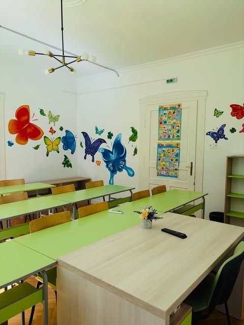 Classroom with butterfly murals and green desks