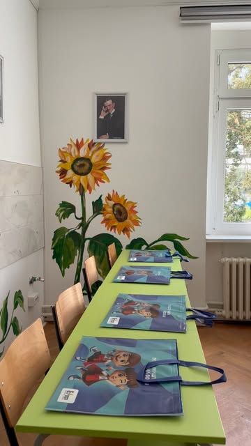 Classroom with a sunflower mural and gift bags laid out on green desks